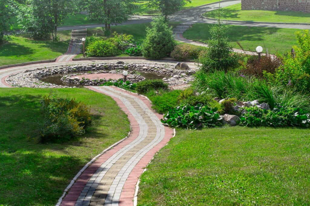 cobbled path in the park and decorative pond. Landscape design concept