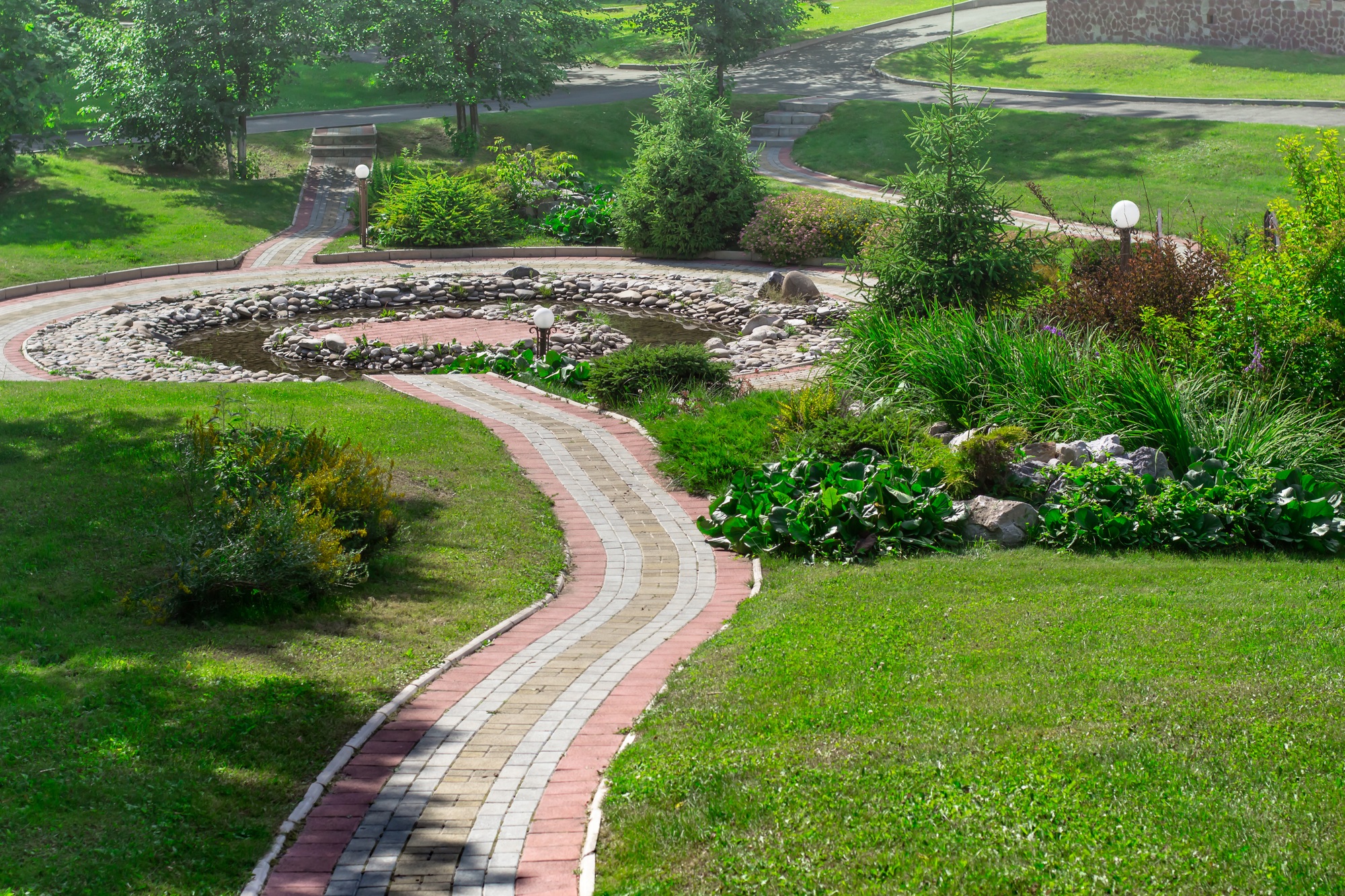 cobbled path in the park and decorative pond. Landscape design concept